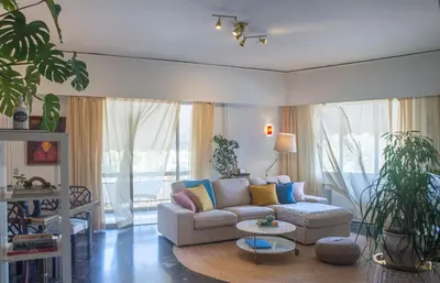 a living room with a couch and a table at Nina's cozy apartment in Mikrolimano in Piraeus