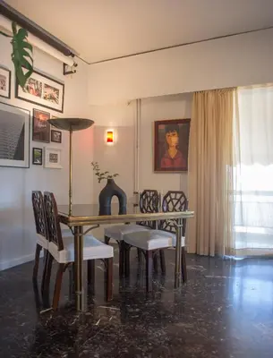 a dining room with a table and chairs and a window at Nina's cozy apartment in Mikrolimano in Piraeus