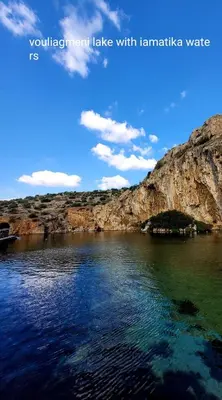 a large body of water next to a mountain at Little Beach Chalet in Saronida