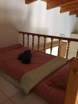 a bed with a backpack sitting on top of it at Little Beach Chalet in Saronida