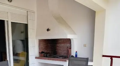 a living room with a brick fireplace in a house at Little Beach Chalet in Saronida