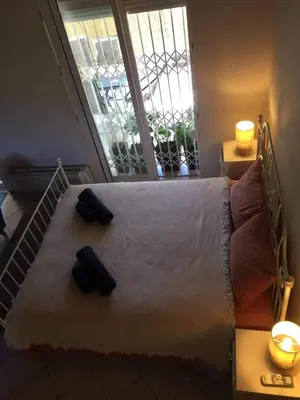 a bedroom with a bed with two black slippers on it at Little Beach Chalet in Saronida