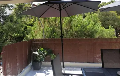 an umbrella on a patio with a table and chairs at Little Beach Chalet in Saronida