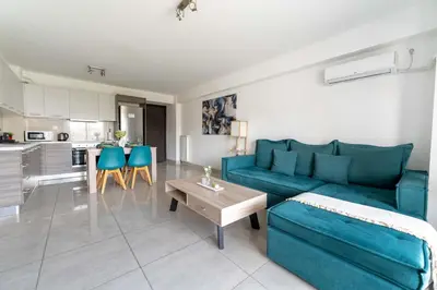 a living room with a blue couch and a table at Modern spacious apartment located in Piraeus (B8) in Piraeus