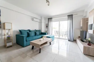 a living room with a blue couch and a table at Modern spacious apartment located in Piraeus (B8) in Piraeus