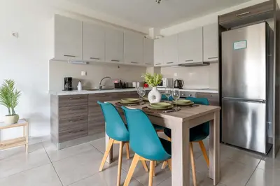 a kitchen with a wooden table and blue chairs at Modern spacious apartment located in Piraeus (B8) in Piraeus