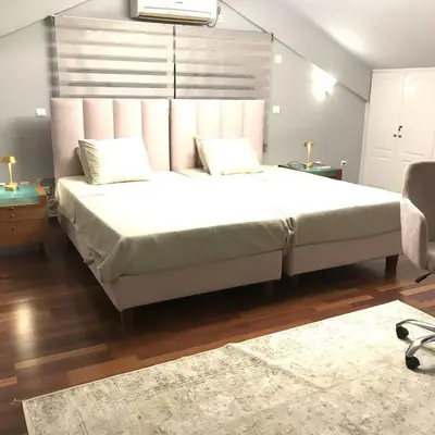 a bedroom with a large bed with a large headboard at Beautiful maisonette with a view to the mountains and the sea in Aghia Marina