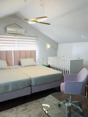 a bedroom with a bed and a chair and a crib at Beautiful maisonette with a view to the mountains and the sea in Aghia Marina