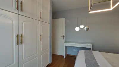 a bedroom with white cabinets and a bed in it at Beautiful maisonette with a view to the mountains and the sea in Aghia Marina