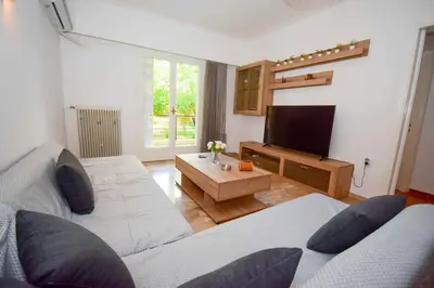 a living room with two beds and a flat screen tv at Filoxenia Apartment Athens in Athens