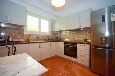 a kitchen with white cabinets and a stainless steel refrigerator at Filoxenia Apartment Athens in Athens