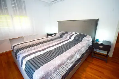 a large bed in a bedroom with a large window at Filoxenia Apartment Athens in Athens