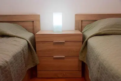 a bedroom with two beds and a night stand with a candle at Filoxenia Apartment Athens in Athens