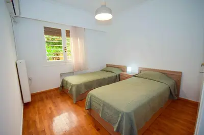 a bedroom with two beds and a window at Filoxenia Apartment Athens in Athens