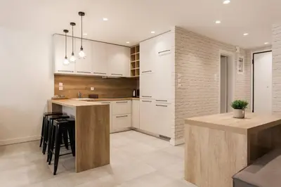 a kitchen with white cabinets and a island with bar stools at Chic Apartment - Strolling to the Athenian streets in Athens