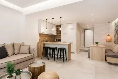 a living room with a couch and a kitchen at Chic Apartment - Strolling to the Athenian streets in Athens