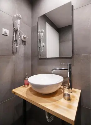 a bathroom with a bowl sink and a mirror at Olvia Suites in Athens