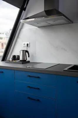 a kitchen with blue cabinets and a sink and a stove at Olvia Suites in Athens