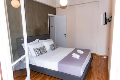 a bedroom with a bed with white sheets and pillows at Pnyka Apartment 3 in Athens