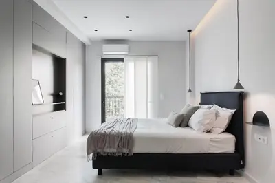 a bedroom with a bed with white walls and a window at Marvelous 2BR Apartments with balcony by UPSTREET in Athens