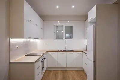 a white kitchen with white cabinets and a sink at Central & Comfy apartment 2mins walking from metro in Athens