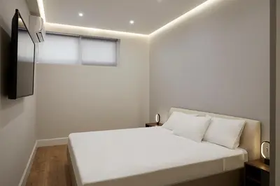 a bedroom with a white bed and a window at Central & Comfy apartment 2mins walking from metro in Athens