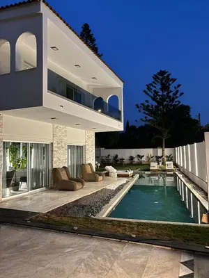 a house with a swimming pool in front of it at Luxury Villa with Pool, BBQ & Garden in Vouliagmeni in Athens