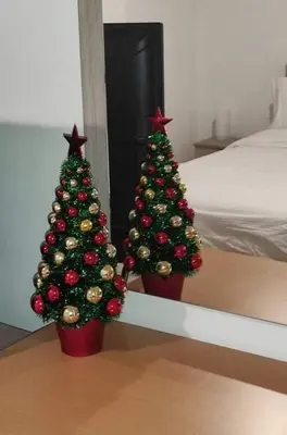 two christmas trees in a room with a bed at Lovely apartment next to Syggrou Fix metro station in Athens