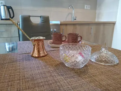 a table with cups and a glass bowl on it at Lovely apartment next to Syggrou Fix metro station in Athens