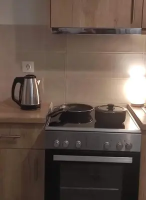 a stove with three pots and pans on top of it at Lovely apartment next to Syggrou Fix metro station in Athens