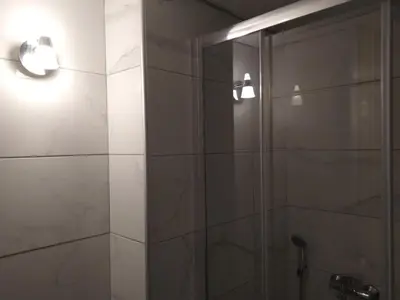 a bathroom with a shower with a glass door at Lovely apartment next to Syggrou Fix metro station in Athens