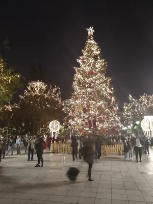 a christmas tree with people walking in front of it at Lovely apartment next to Syggrou Fix metro station in Athens