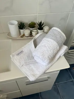 two towels sitting on a shelf in a bathroom at ILION Air Host - near Athens International Airport in Markopoulo