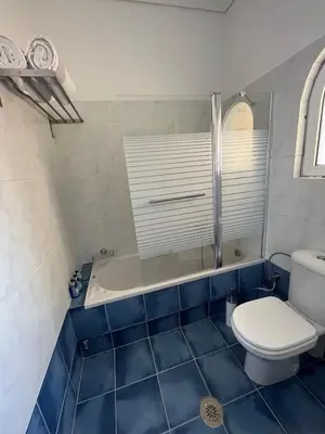 a bathroom with a toilet and a bath tub at ILION Air Host - near Athens International Airport in Markopoulo