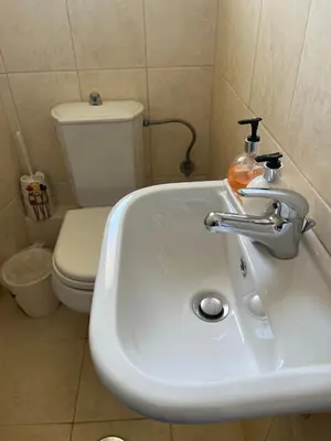 a bathroom with a white sink and a toilet at ILION Air Host - near Athens International Airport in Markopoulo