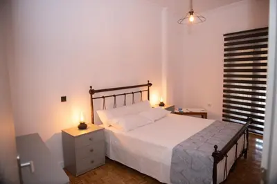 a bedroom with a bed and a night stand with two candles at Sophia’s place in Piraeus