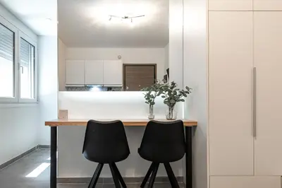 a kitchen with a table and two black chairs at Phaedrus Living: City Center Executive Flat Stadiou in Athens