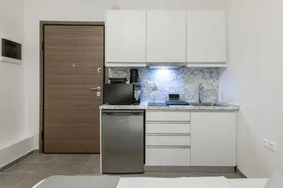 a kitchen with white cabinets and a refrigerator at Phaedrus Living: City Center Executive Flat Stadiou in Athens