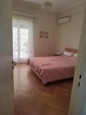 a bedroom with a large bed and a window at lovely penthouse at the center! in Athens