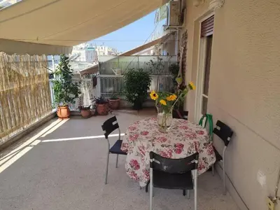 a table with a vase of flowers on a patio at lovely penthouse at the center! in Athens