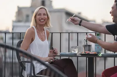 a woman sitting at a table on a balcony at Pure Hotel by Athens Prime Hotels in Athens
