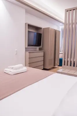 a bedroom with a large bed and a television at Millennial Apartments Trikoupi in Athens