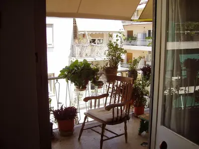 a balcony with a table and chairs and potted plants at PRIVATE BEDROOMS IN SHARED APARTMENT 135 SM ATHENS Center in Athens
