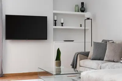 a living room with a couch and a tv on a wall at KASO - Fotomara in Athens