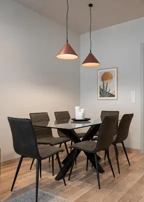 a dining room with a black table and chairs at KASO - Fotomara in Athens