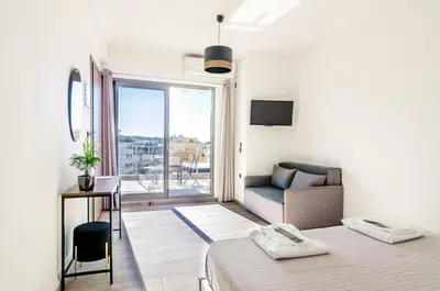 a bedroom with a bed and a couch and a window at Dreamy Athens Loft with City View in Athens