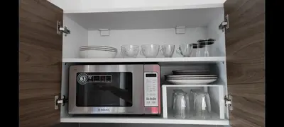 a microwave in a cabinet with plates and glasses at Dreamy Athens Loft with City View in Athens