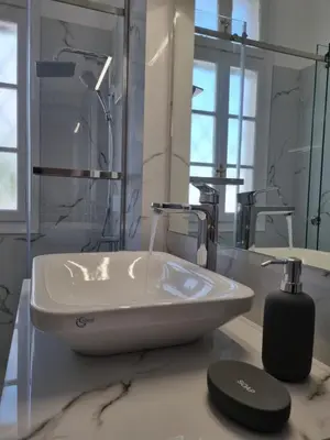 a white bathroom with a sink and a mirror at Hall Apartments & Rooms - by Avelink in Spáta