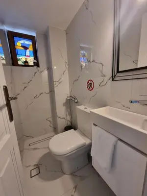a white bathroom with a toilet and a sink at Hall Apartments & Rooms - by Avelink in Spáta