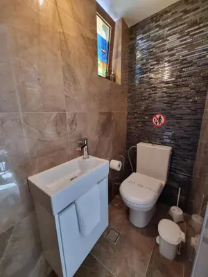 a bathroom with a white sink and a toilet at Hall Apartments & Rooms - by Avelink in Spáta